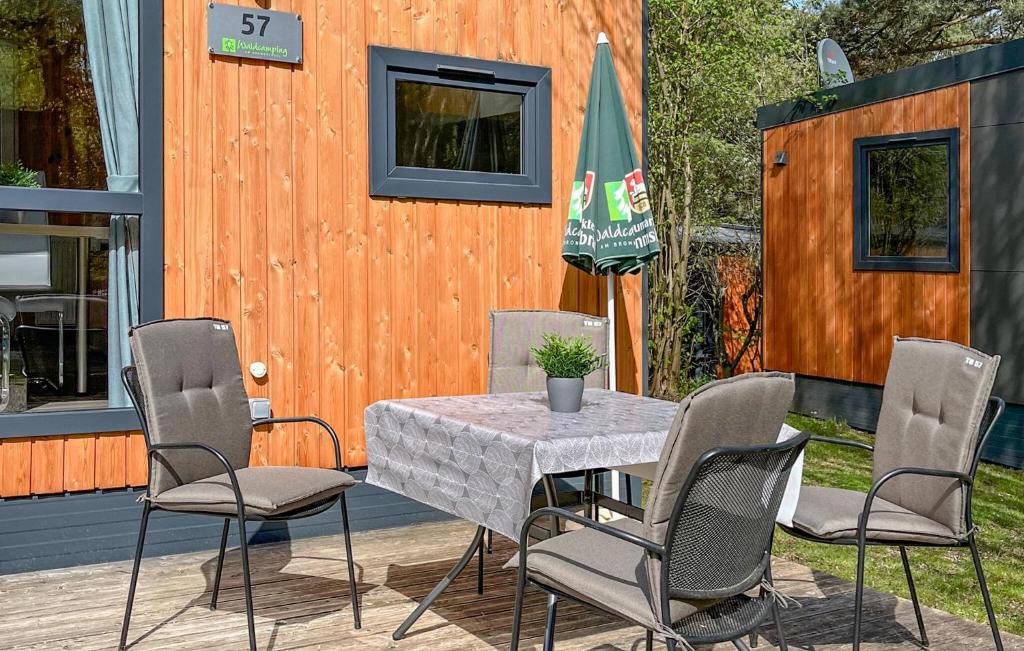 einen Tisch und Stühle auf einer Terrasse mit einem Gebäude in der Unterkunft Tiny Haus 57 Am Brombachsee in Pleinfeld