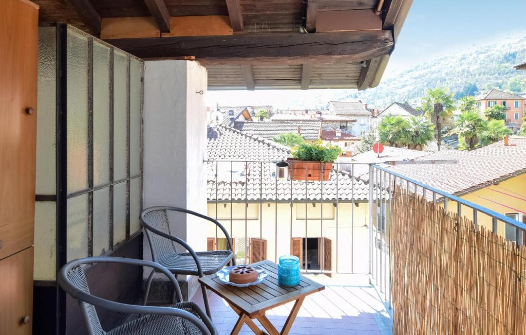 uma varanda com cadeiras e uma mesa e vista para a cidade em 1 Bedroom Pet Friendly Home In Baveno em Baveno