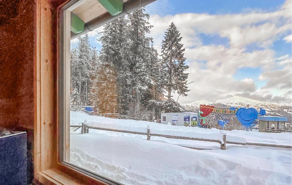 ein Fenster mit Blick auf einen schneebedeckten Hof in der Unterkunft Ferienhaus Am Katschberg in Katschberghöhe