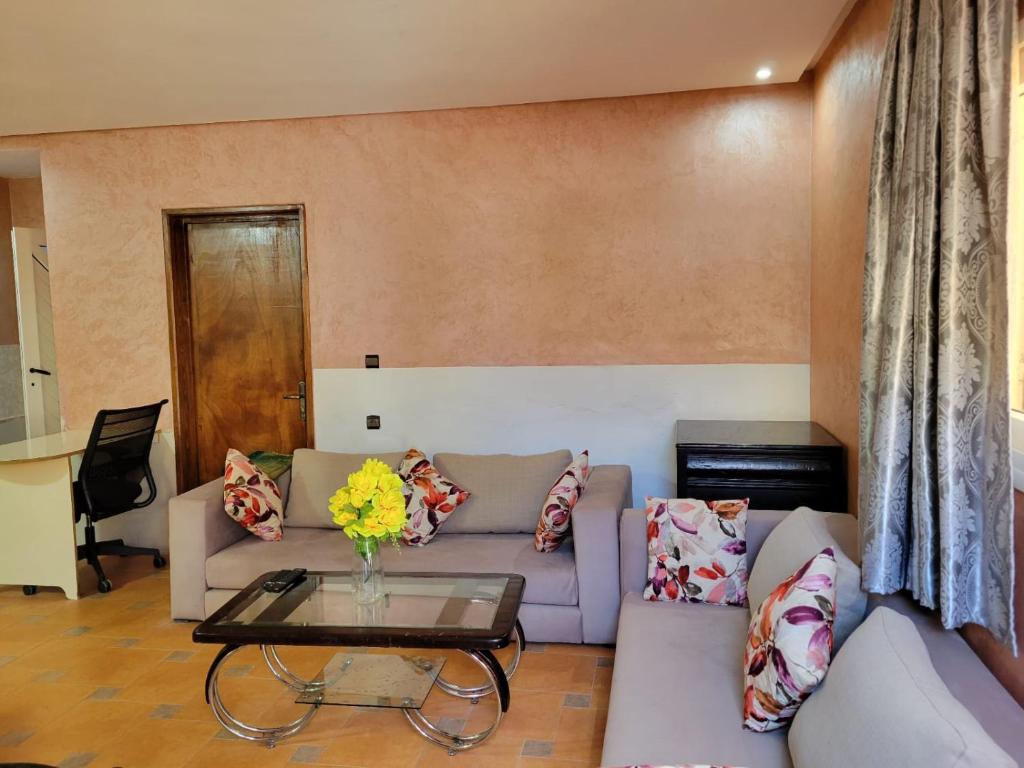 uma sala de estar com um sofá e uma mesa em Imi Ouaddar Apartment just Steps from the Beach em Agadir nʼ Aït Sa