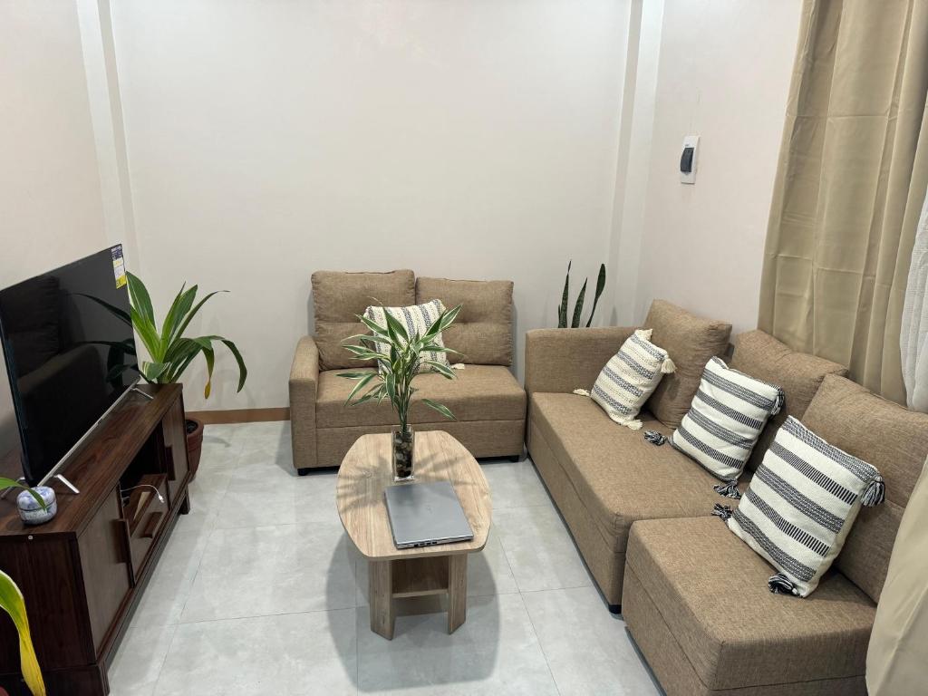 - un salon avec un canapé et une télévision dans l'établissement Comfy Staycation III in Sorsogon City, à Sampong