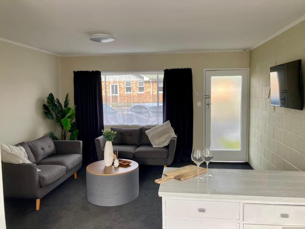 a living room with a couch and a table at 108 by the Lake in Taupo