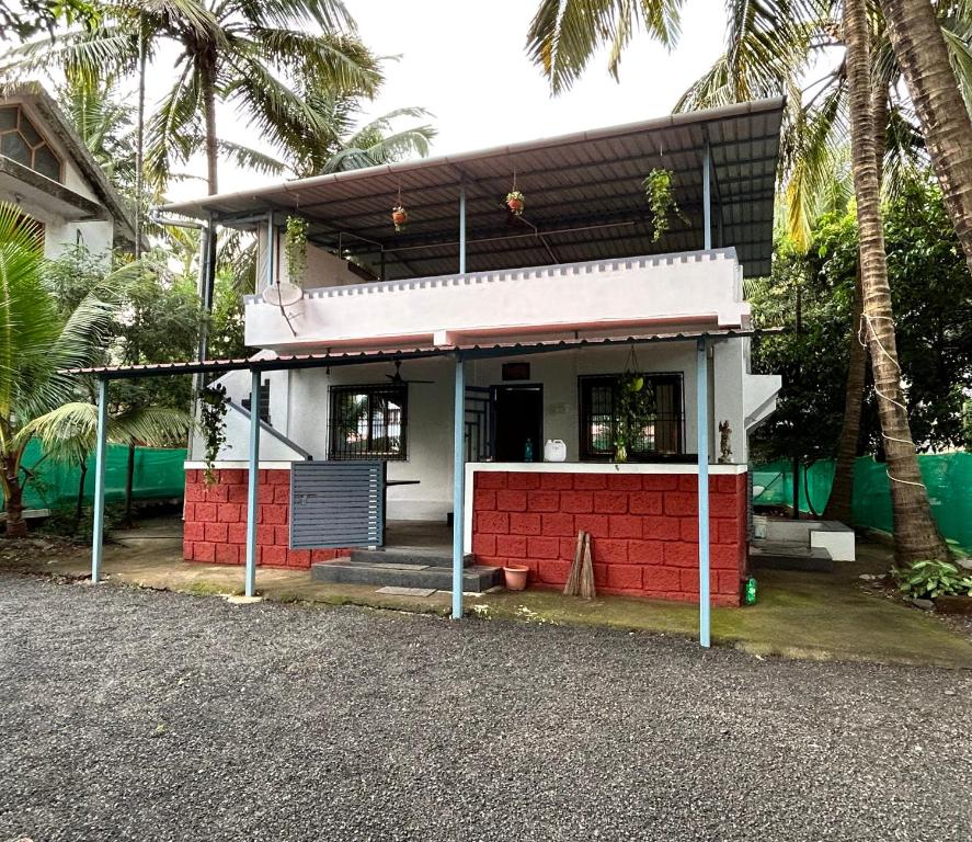 a small red and white house with palm trees at Red Velvet Villa in Kīhīm