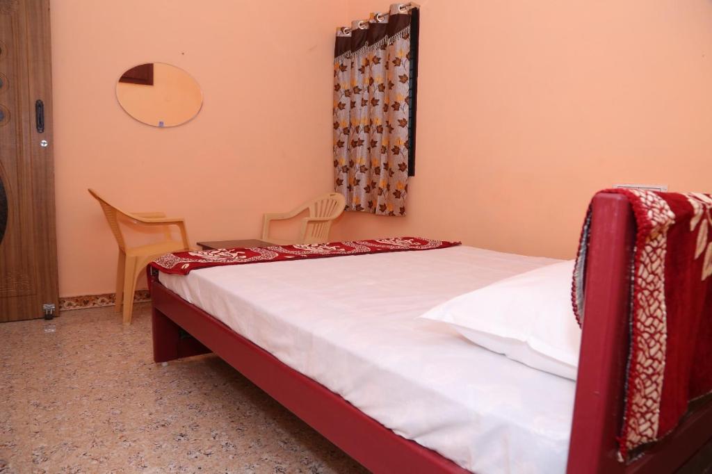 - une chambre avec un lit et deux chaises dans l'établissement SURUkuttyYATRA, à Rameswaram