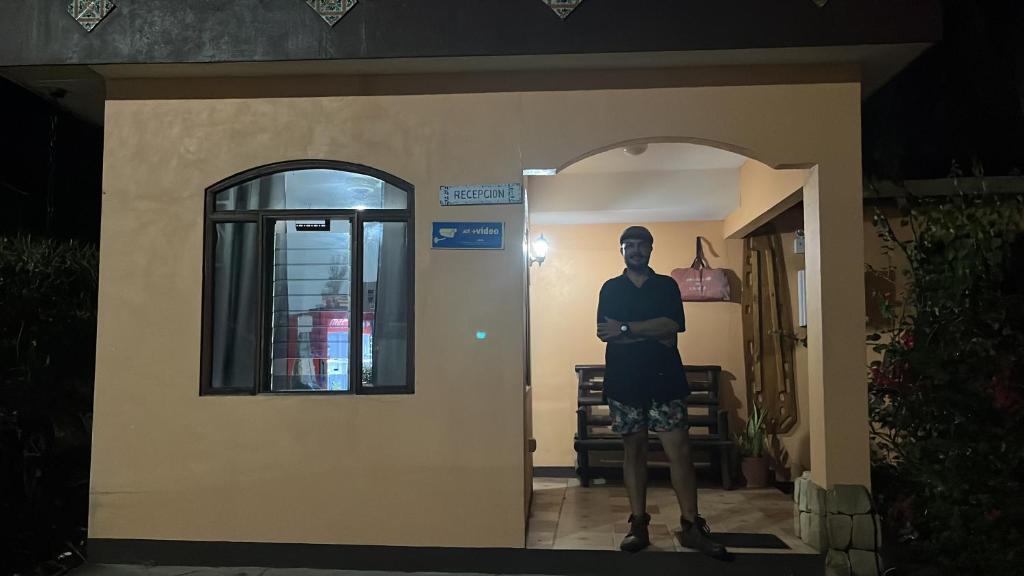 a man standing in the doorway of a house at Hotel Nacaome Blue Zone in Tapantí