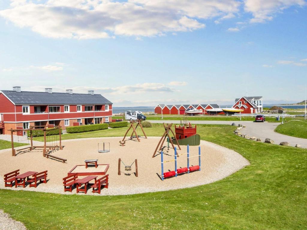 un parque con un parque infantil con bancos y un columpio en Holiday home Lemvig XLIV en Lemvig