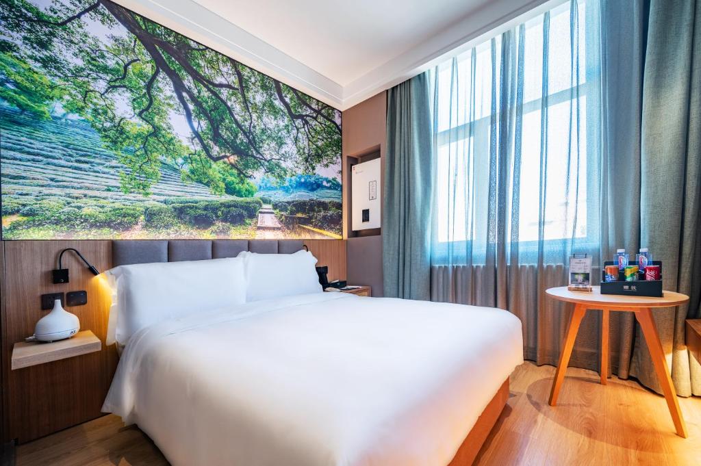 um quarto com uma cama grande e uma janela grande em Qiuguo Hotel - Beijing Chaoyang Branch em Pequim