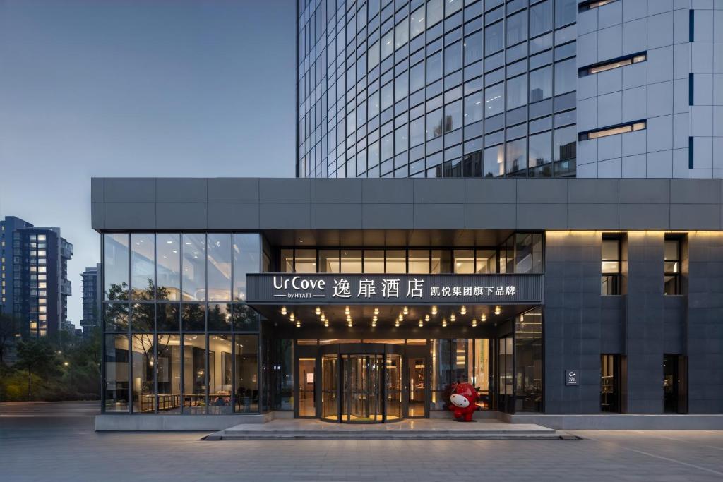 a building with a red fire hydrant in front of it at UrCove by Hyatt Tianjin West Railway STN in Tianjin