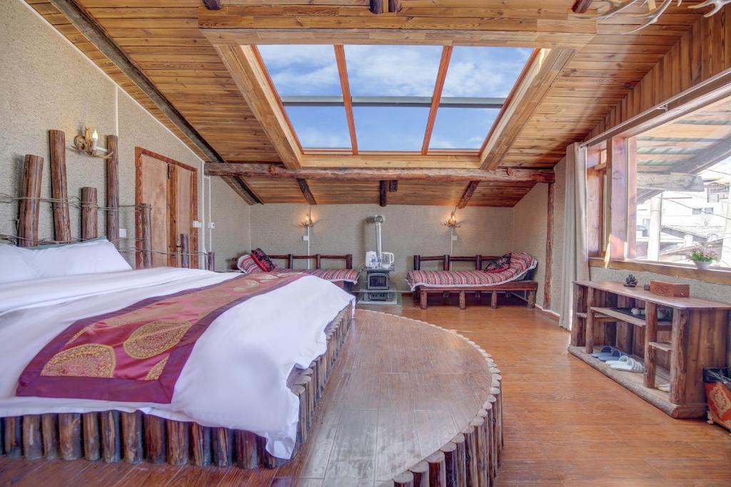 um quarto com uma cama grande e uma janela grande em Shangri-La Youran Valley Inn em Shangri-La
