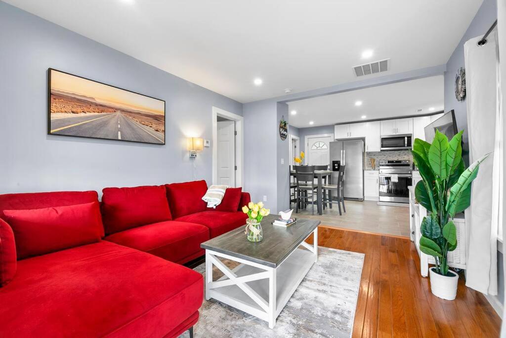 3 Bedroom Apartment on Forestville Bristol في بريستول: غرفة معيشة مع أريكة حمراء وطاولة