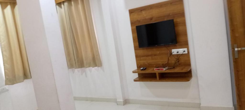 ein Wohnzimmer mit einem TV und einem Tisch in der Unterkunft Hotel 7star near airport in Indore