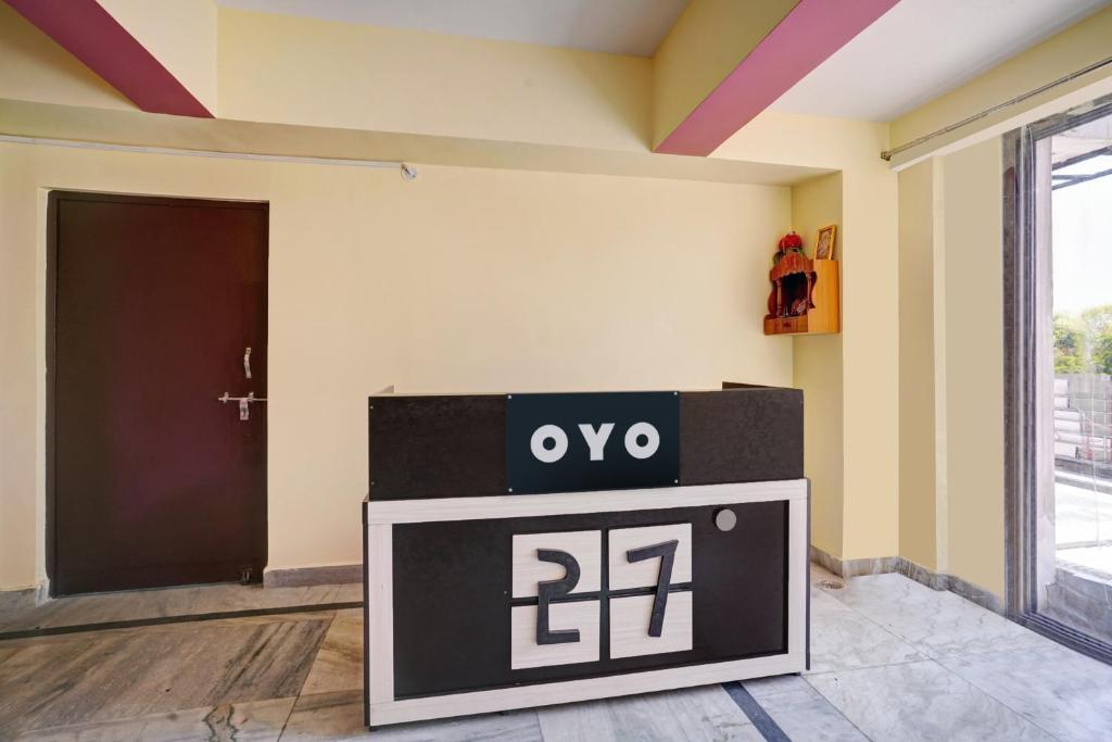 ein Zimmer mit einer Uhr vor einer Tür in der Unterkunft OYO 27 DEGREE HOTEL in Jamshedpur