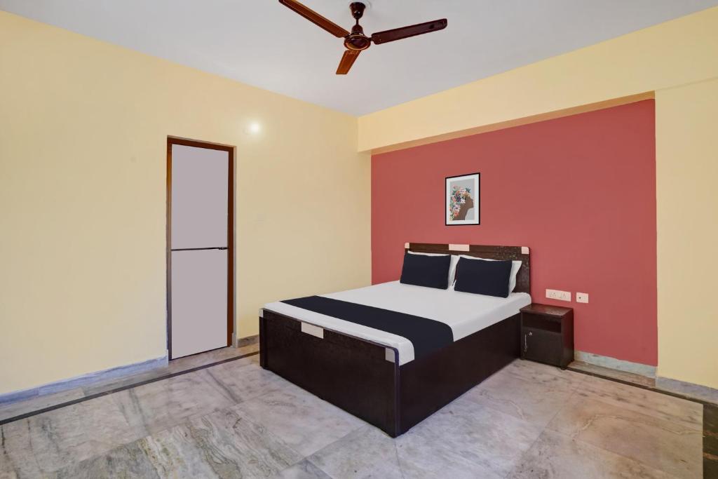 una camera con letto e ventilatore a soffitto di OYO 27 DEGREE HOTEL a Jamshedpur