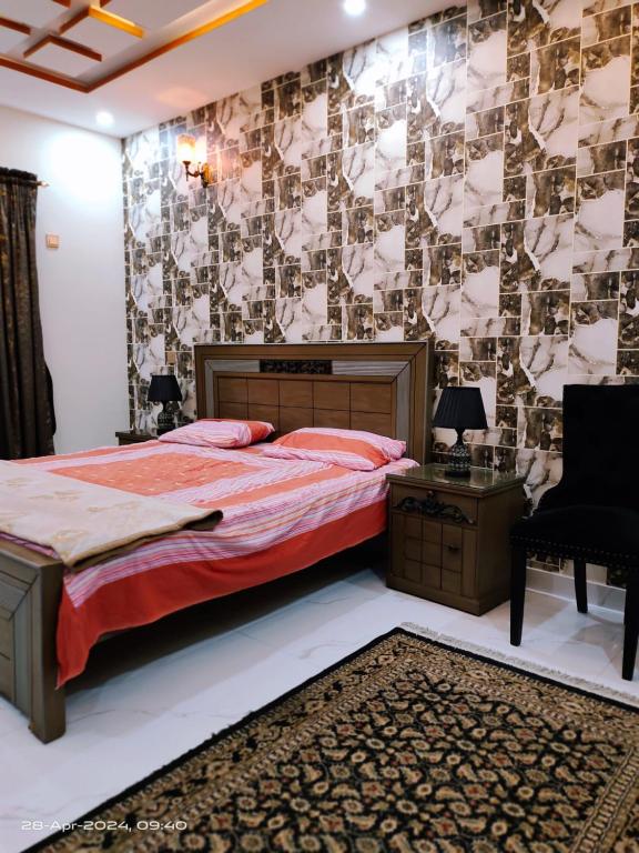 a bedroom with a bed and a wall covered in wallpaper at 2 bedrooms Independent house Valencia town Lahore in Lahore