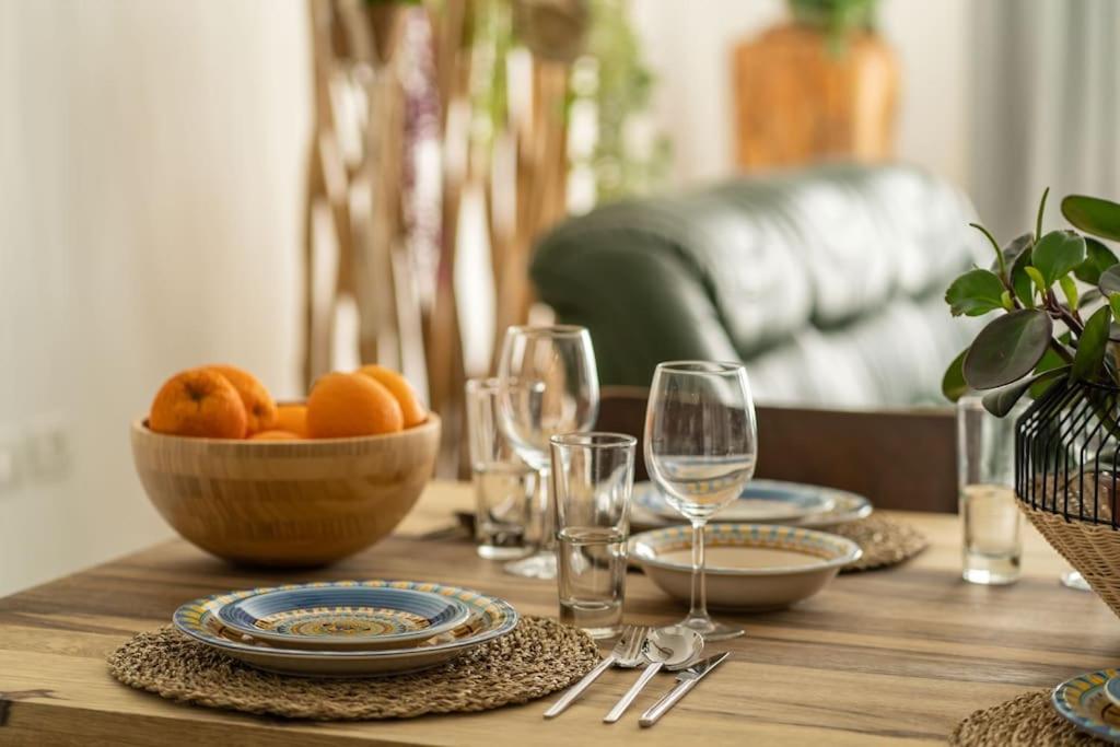 una mesa de madera con un tazón de naranjas y copas de vino en HaKerem new luxury 3 rooms apartments and 2 rooms penthaus, en Tel Aviv