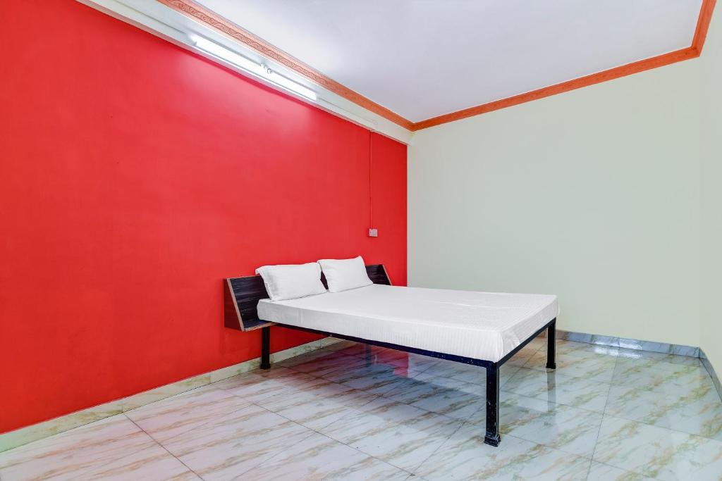 a bed in a room with a red wall at OYO Hotel Wonder Hills in Hinjewadi