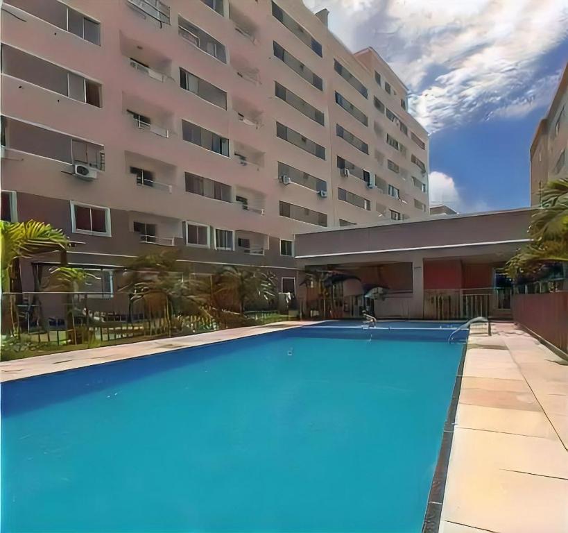 a large swimming pool in front of a building at Apartamento bem localizado em fortaleza in Fortaleza