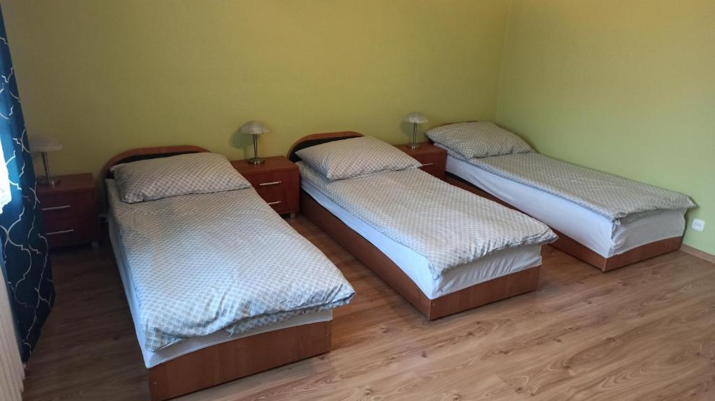 3 camas en una habitación con suelo de madera en Giżycko WP30, en Giżycko