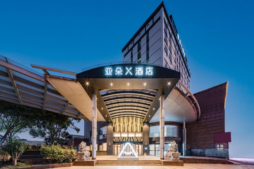 a building with a clock on the top of it at Atour X Hotel Shanghai Anting Metro Station in Jiading