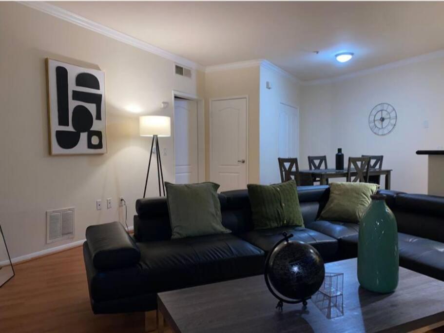 een woonkamer met een zwarte bank en een tafel bij Urban Haven at Orsini in Los Angeles