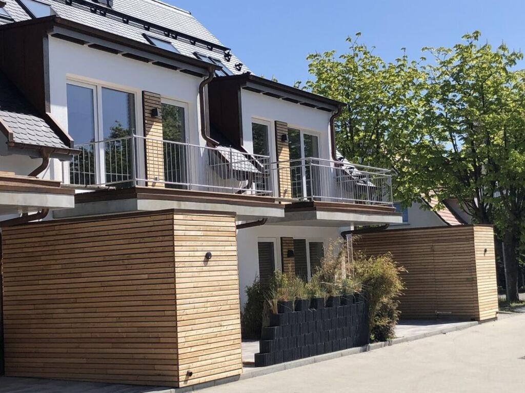 a house with a wooden fence in front of it at Seaside 2 Modern retreat in Prerow