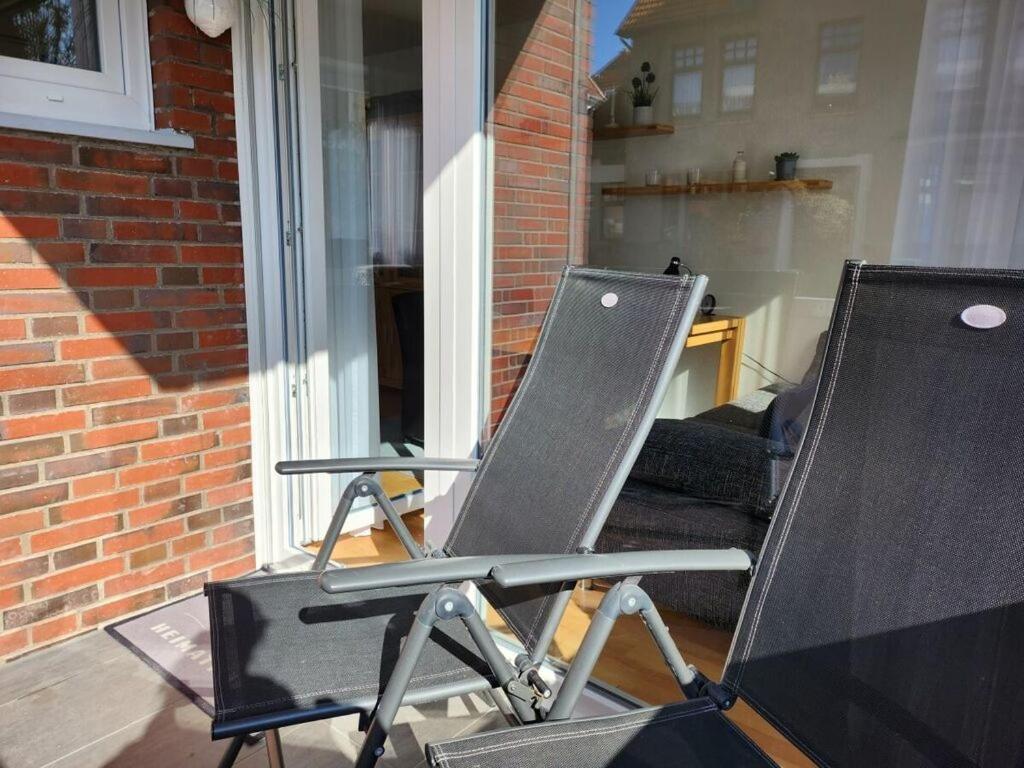 dwa krzesła siedzące na ganku domu w obiekcie Sound of the sea Modern retreat w mieście Wangerooge