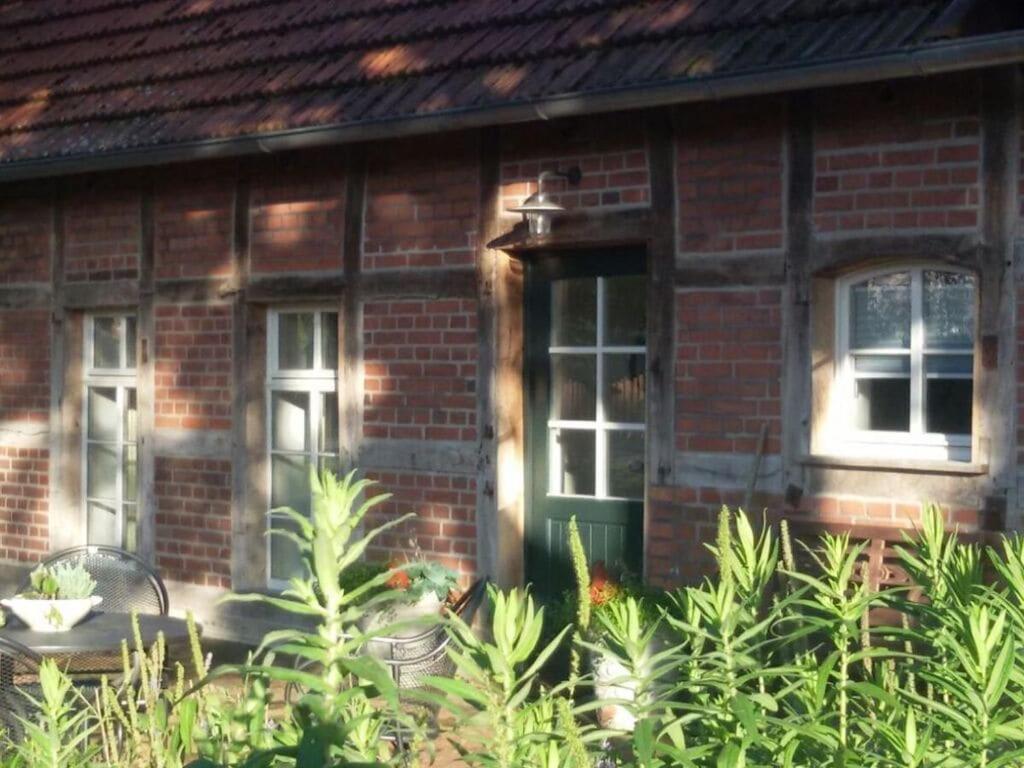 een bakstenen huis met een groene deur en wat planten bij Rose Cottage Comfortable holiday residence in Petershagen