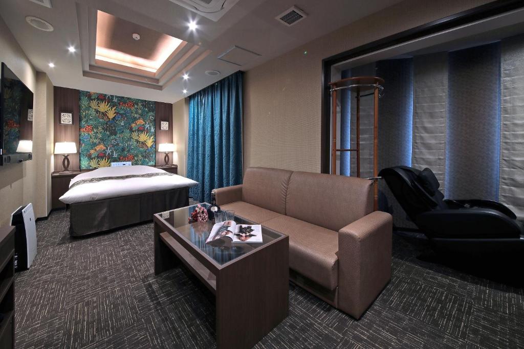 名古屋的住宿－M'z HOTEL，酒店客房设有一张沙发和一张床