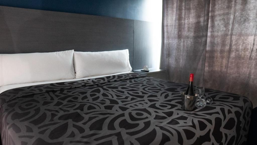ein Schlafzimmer mit einem Bett mit einer Flasche Wein darauf in der Unterkunft Smae in Mexiko-Stadt