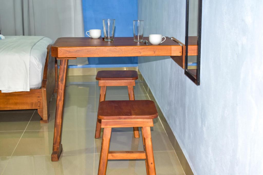 un tavolo in legno con 2 sgabelli e uno specchio di Cabinas Ecologicas Rio Brasil a Tabores