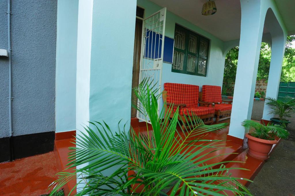 une terrasse couverte avec des chaises et des plantes dans l'établissement Janibichi Adventures hostel, à Moshi