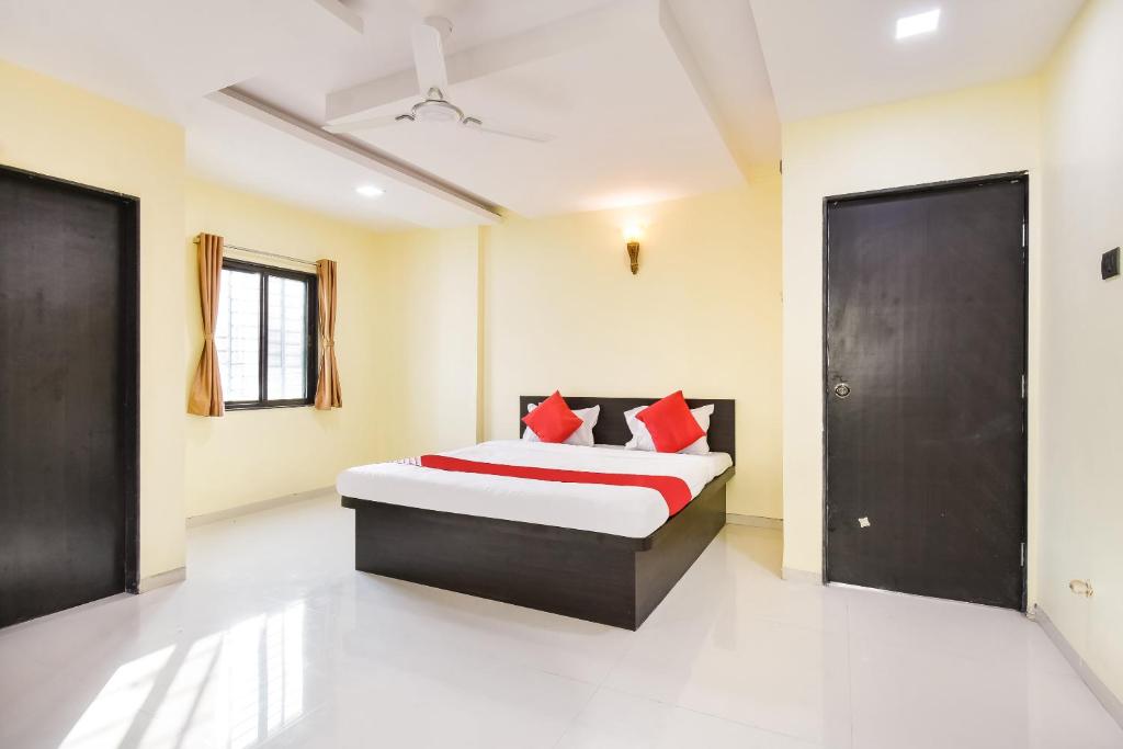 um quarto com uma cama com almofadas vermelhas em OYO Flagship Hotel Manish Inn em Aurangabad