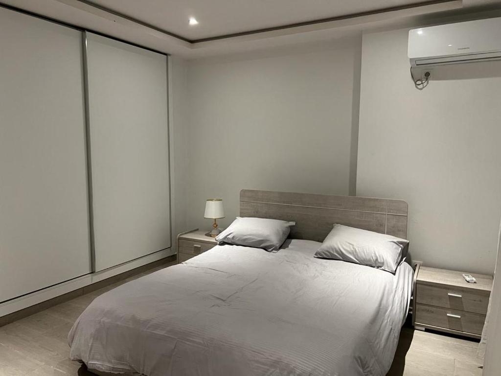 um quarto com uma cama branca e 2 almofadas em Pavillon bouchaoui em Cheraga