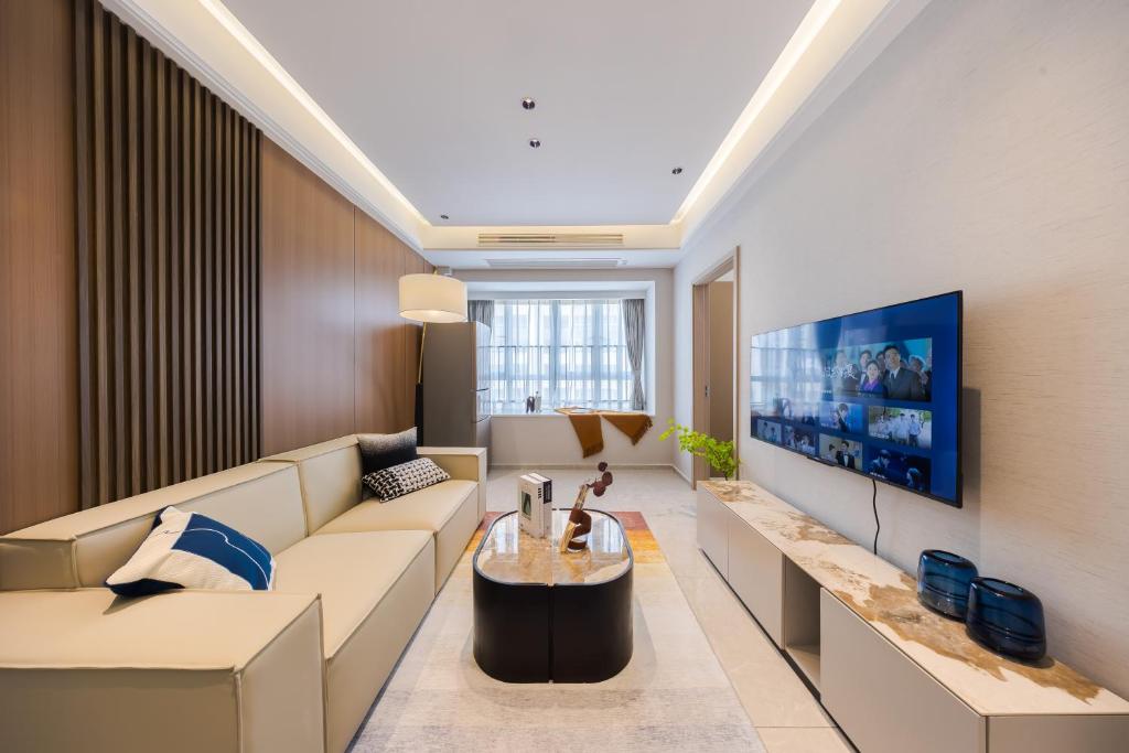 a living room with a couch and a tv at Xi Ke Executive Apartment - Shenzhen Futian Exhibition Center in Shenzhen