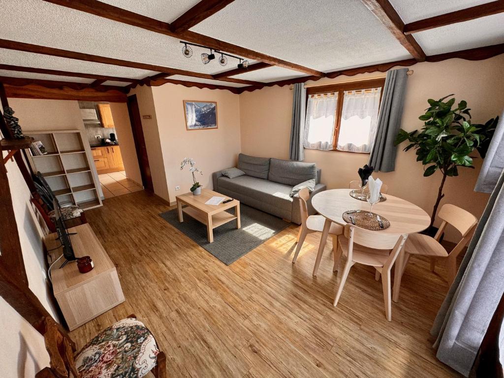 un salon avec une table et un canapé dans l'établissement L'étape du plateau de Corréo, à La Roche-des-Arnauds