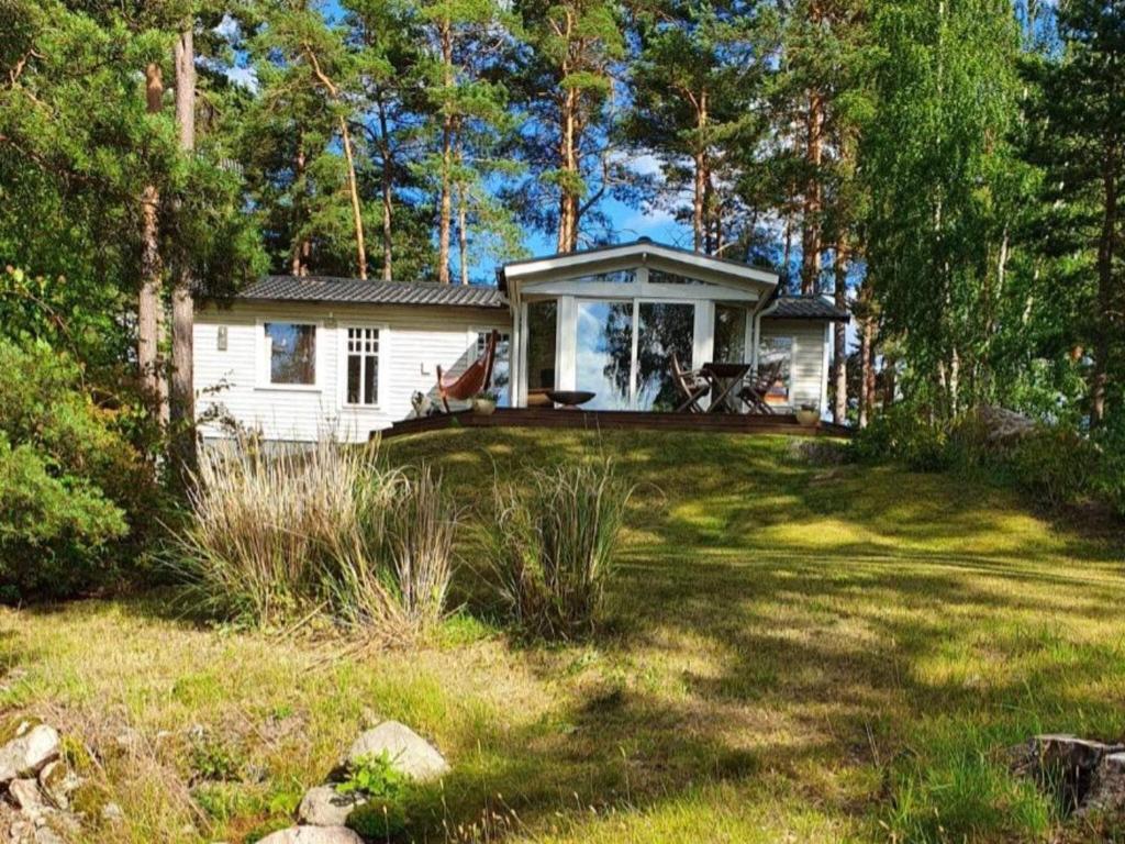une maison blanche avec terrasse couverte dans une cour dans l'établissement Holiday home MÖNSTERÅS VII, à Mönsterås
