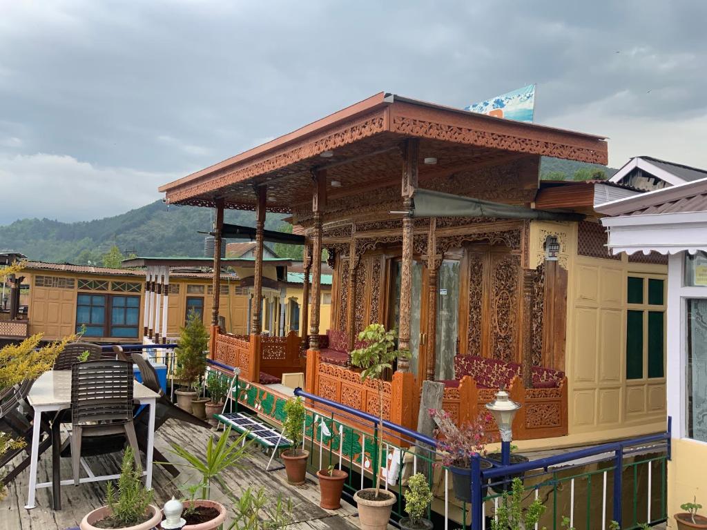 a house with a balcony with a table and chairs at Movie land group of house boats in Srinagar