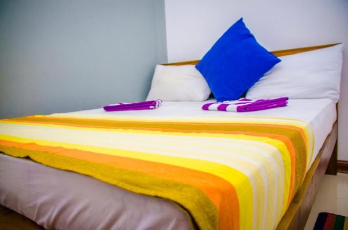Una cama con dos zapatillas encima. en Royal Mount Residance en Sri Jayewardenepura Kotte