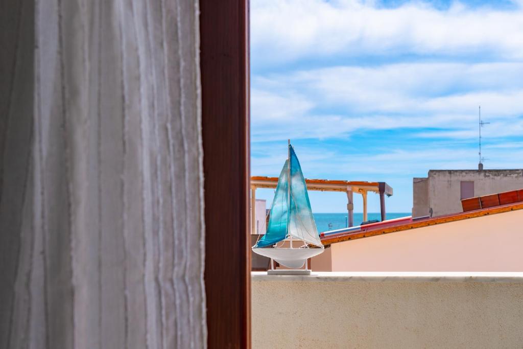 een balkon met een parasol en uitzicht op de oceaan bij A'Mari - Holiday Home - Sciacca in Sciacca