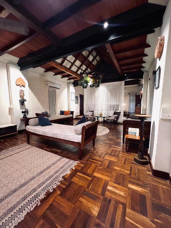 a living room with two beds and a piano at Svarna Heritage in Kalyānpur