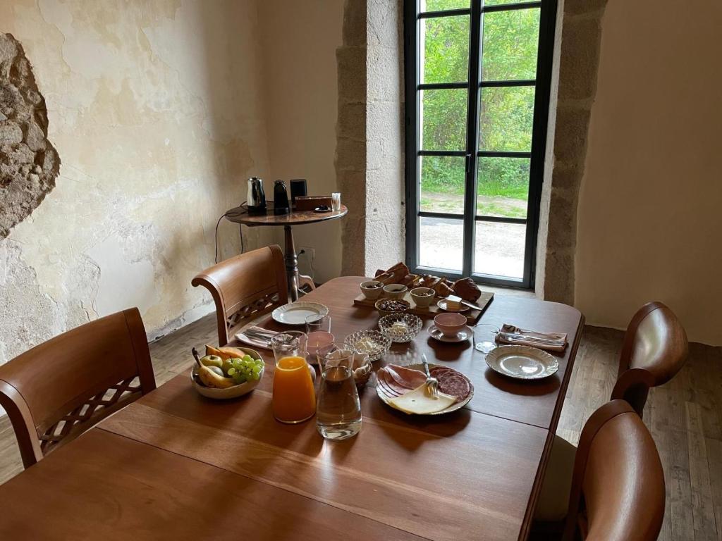 einen Holztisch mit Essen darüber in der Unterkunft Maison G.H. in Champniers-et-Reilhac