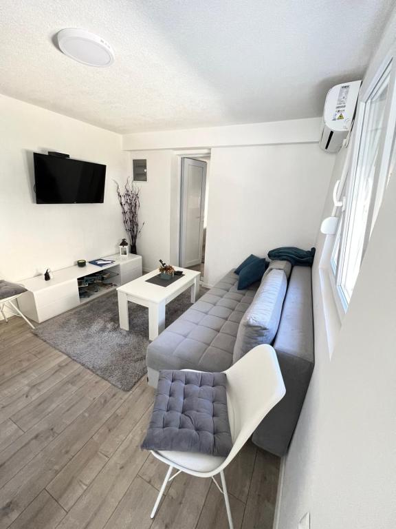 sala de estar con sofá y TV en Apartman Milica, en Trebinje