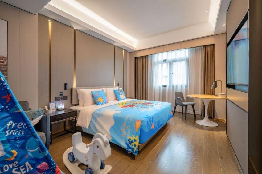 Atour Hotel Shenzhen Luohu Vientiane City في شنجن: غرفة في الفندق بسرير ومكتب وطاولة