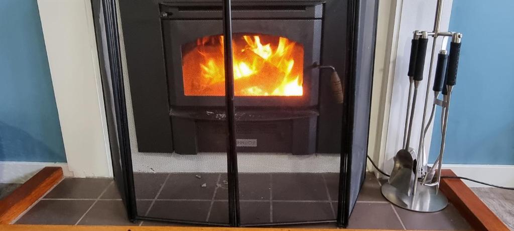 a stove with a fire in it in a room at Views of the Tamar River in Clarence Point