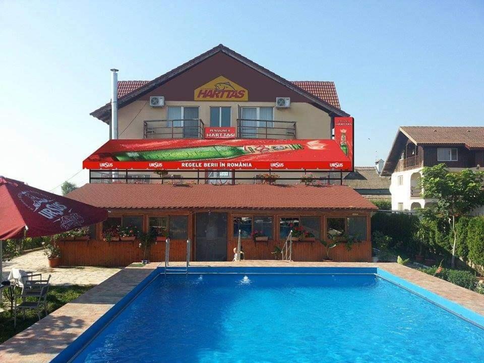 un hotel con piscina frente a un edificio en Pensiunea HARTTAS, en Tulcea