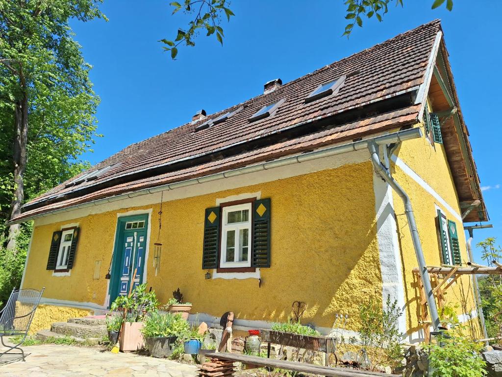 a yellow house with a blue door and windows at Landhaus Hideaway Ruheoase Pool in Pirching am Traubenberg
