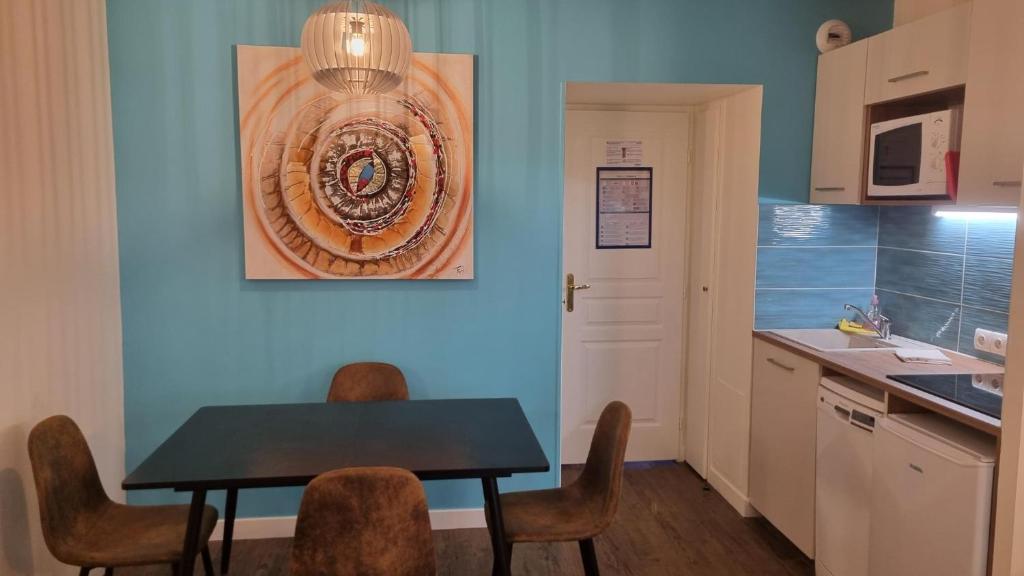 une salle à manger avec une table et des chaises dans une cuisine dans l'établissement 2 pièces avec piscine chauffée, à Deauville