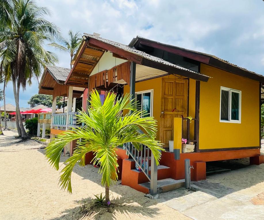 蘇梅島的住宿－Anong Villa，海滩上一棵棕榈树的房子