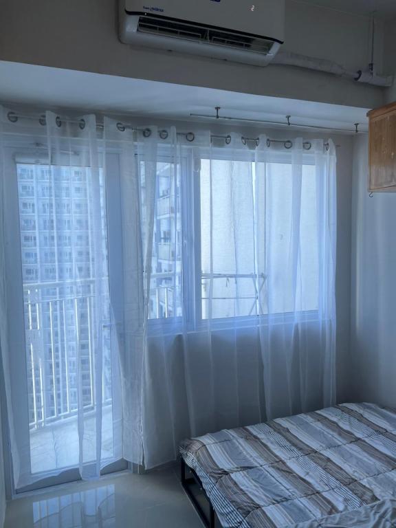 a bedroom with a bed and a large window at 39th Flr Condo Unit with View in Manila