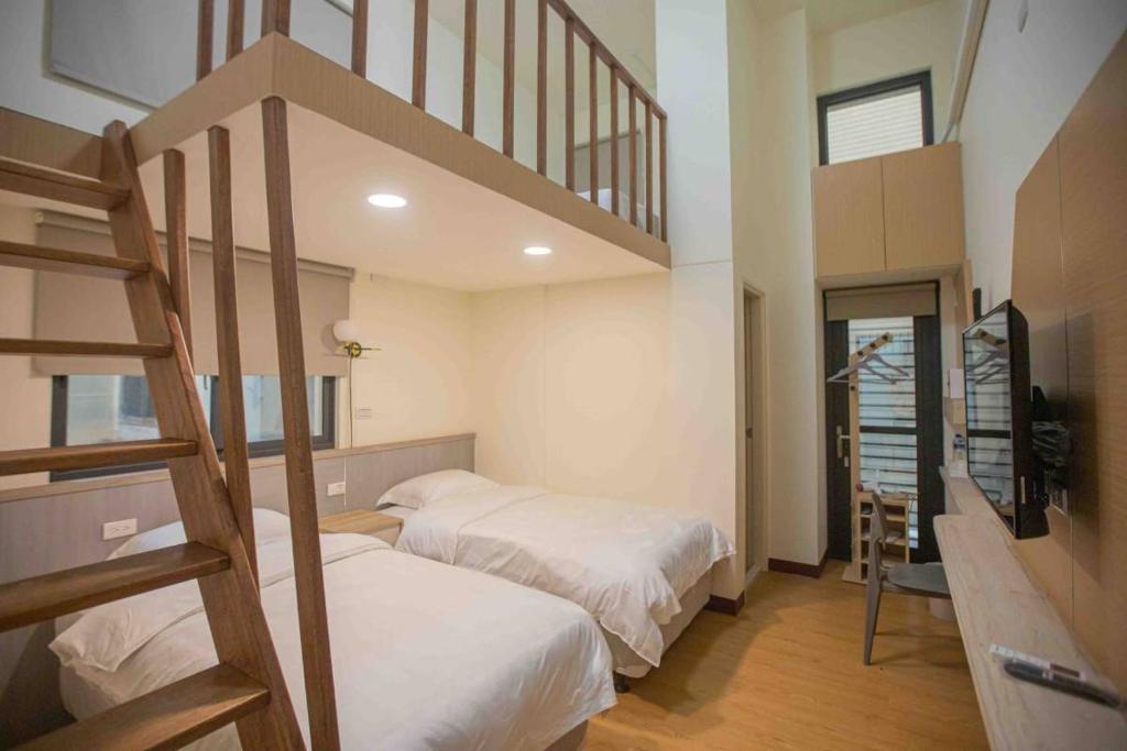 a bedroom with two bunk beds and a staircase at Xianwang Homestay in Jincheng